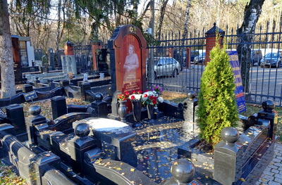 Гранитное надгробье без цветника и карликовая туя в клумбе