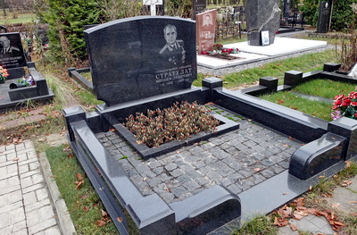 Широкое надгробье с прямоугольным цветником и покрытие брусчаткой
